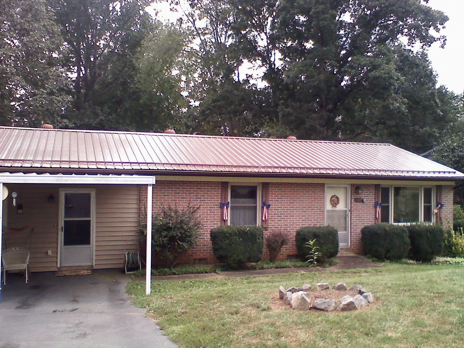 Bronze metal roof and carport on a brick ranch home — Roof Repair work by our crew in Icard